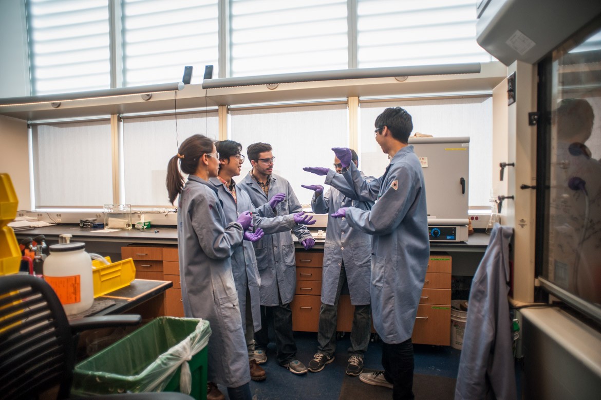 Students engaged in conversation in a chemistry lab.